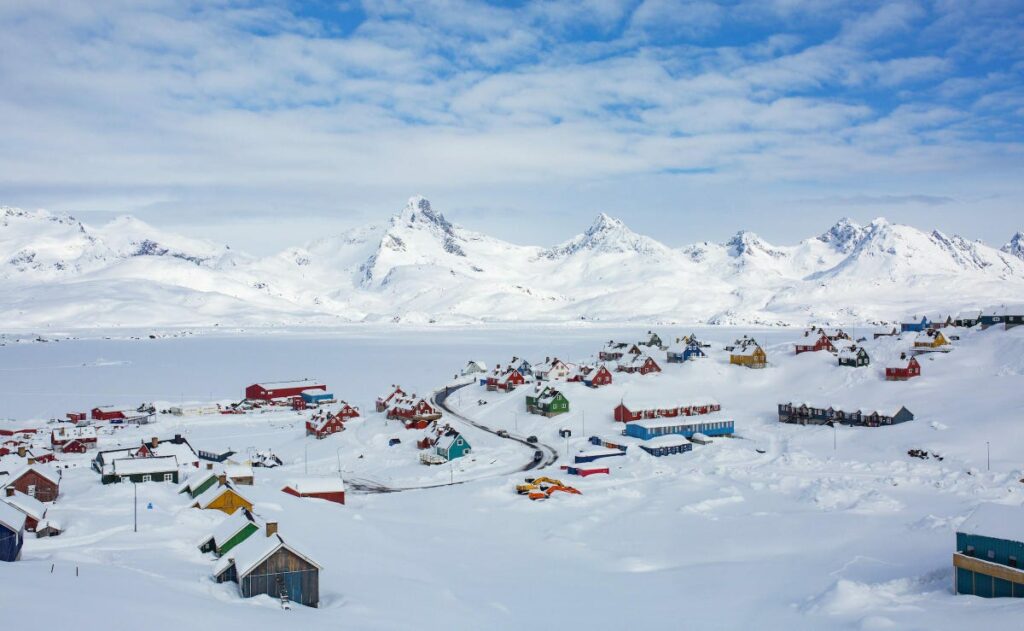 A colourful village blanketed in snow.
