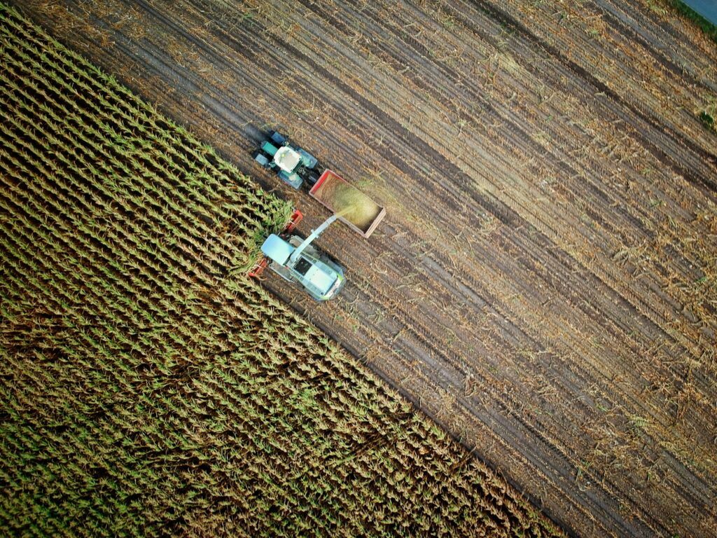 Tractors harvesting crops from fields