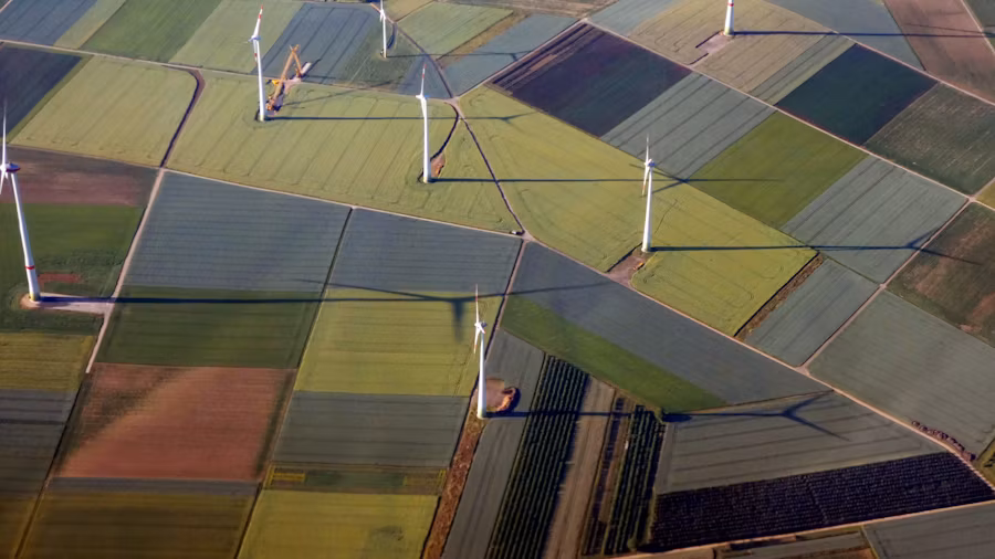 Wind turbines spread out across green fields