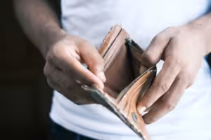 Man looking through wallet for money